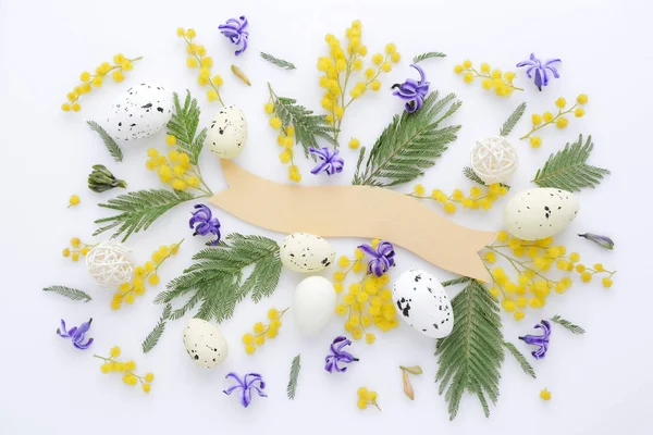 Paskalya yumurtaları ve Mimoza ve sümbül çiçekleri beyaz arka plan üzerinde. Üstten Görünüm. — Stok fotoğraf