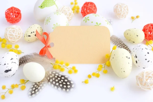 Πασχαλινά αυγά και μιμόζα λουλούδια σε λευκό φόντο με κενή κάρτα να χαιρετήσει — Φωτογραφία Αρχείου