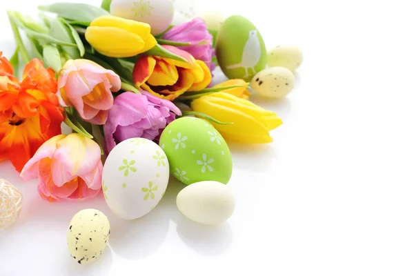 Oeufs de Pâques avec des fleurs de tulipes sur fond blanc — Photo