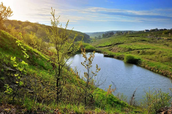 Paisagem ensolarada primavera com um lago. Vista da colina — Fotografia de Stock