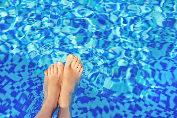 青い水のプールを背景に女性の足 — ストック写真