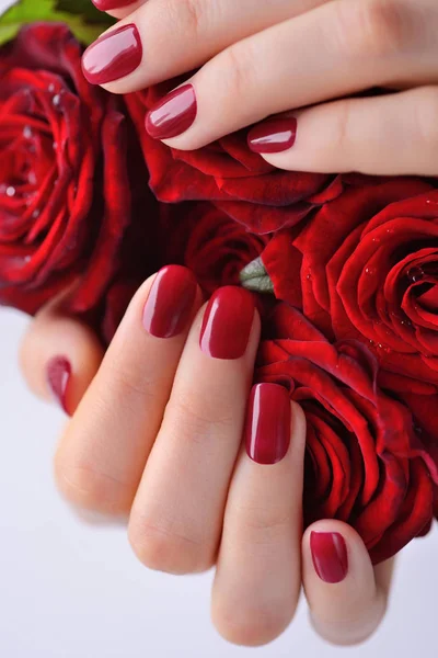 Ręce kobiety z manicure czerwony bukiet czerwonych róż. Z bliska — Zdjęcie stockowe