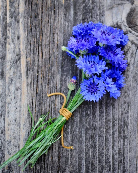 Cornflower blue flowers (Centaurea cyanus) on an old wooden table. Top view. — Stock Photo, Image