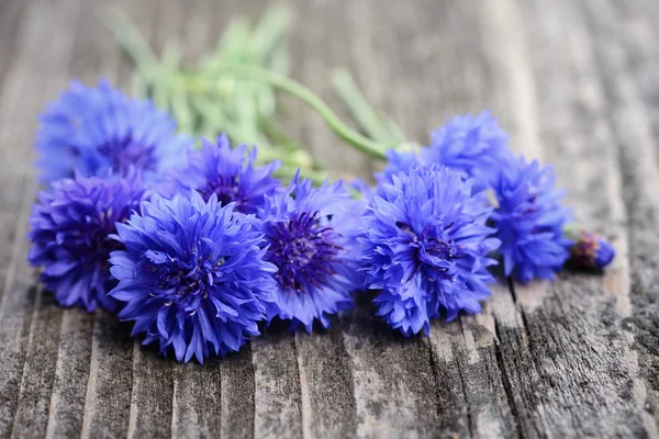 Búzavirág kék virágok (Centaurea cyanus) egy régi fából készült asztal — Stock Fotó