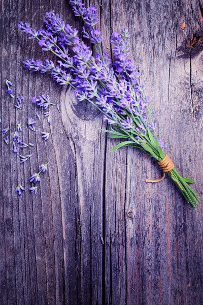 Levandule (Lavandula) květy na staré dřevěné pozadí. Umění fotografie v purple tón. — Stock fotografie