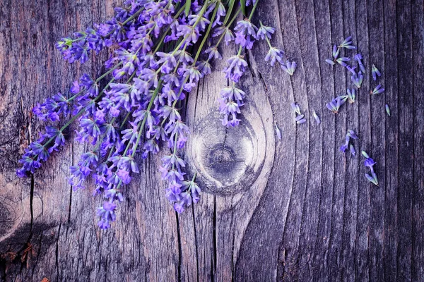 Lavender flowers (Lavandula) on an old wooden background. Art photo in purple tone. — Stock Photo, Image