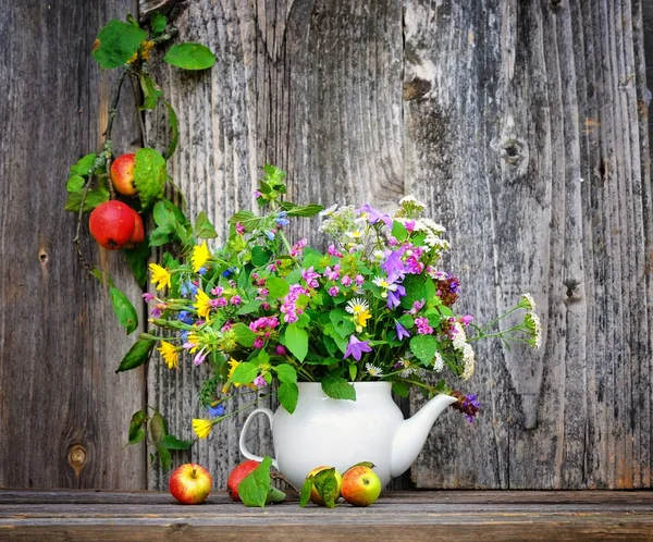 Autumn bouquet of wild flowers and apples — Stock Photo, Image