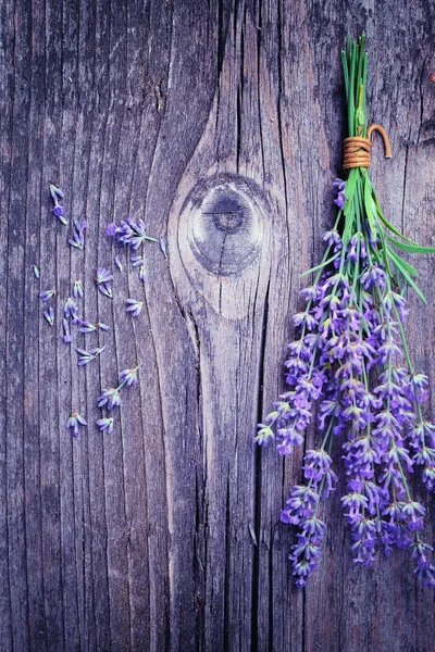 Levandule (Lavandula) květy na staré dřevěné pozadí. Umění fotografie v purple tón. — Stock fotografie