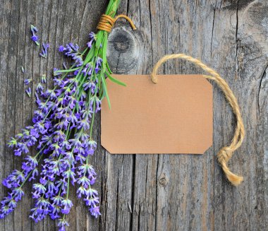 Lavanta çiçekleri (Lavandula) eski bir ahşap masa üstünde kağıt etiket ile