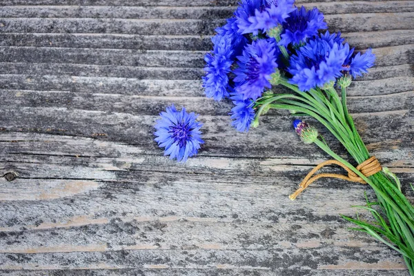 Fleurs bleues de bleuet (Centaurea cyanus) sur une vieille table en bois. Vue du dessus . — Photo