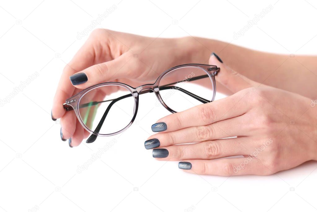 Female hands holding eye glasses on white background