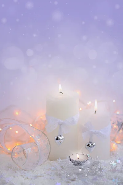 Weihnachtskerzen im Schnee und Weihnachtsbeleuchtung — Stockfoto