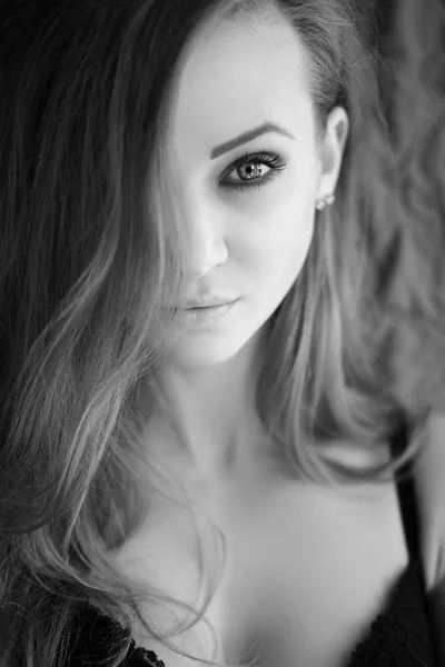 Портрет красивой молодой женщины с длинными волосами, смотрящей в камеру. Черно-белое фото . — стоковое фото