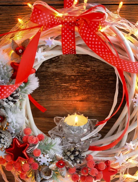Kerze mit Adventskranz und Weihnachtsbeleuchtung auf Holzgrund. — Stockfoto