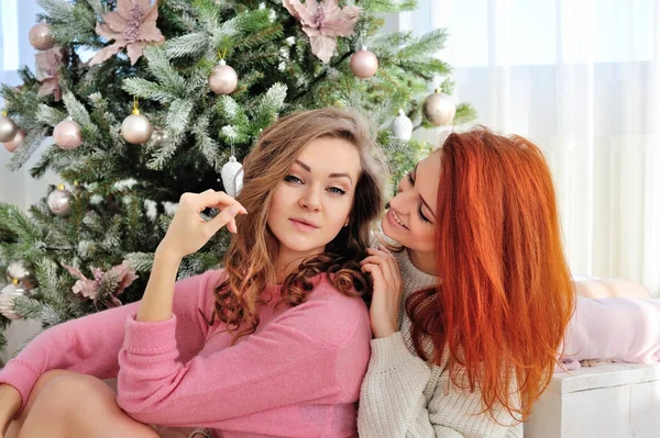 Fiatal gyönyörű nők karácsonyfák közelében. Új év-koncepció. — Stock Fotó