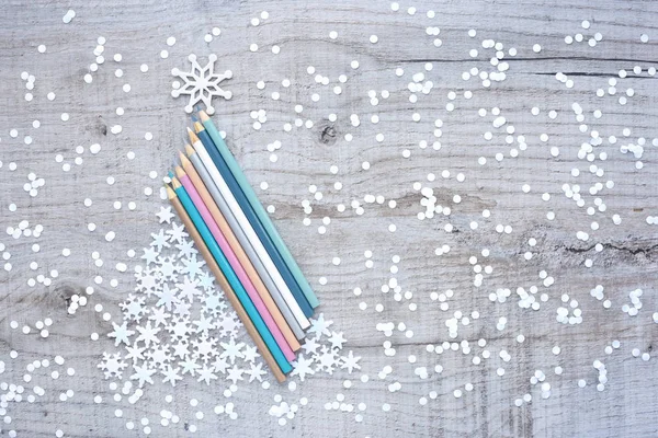 Julgran av pennor och snöflingor på en trä bakgrund. — Stockfoto