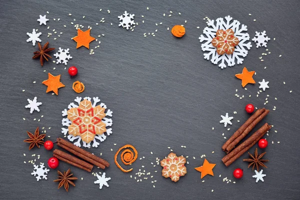 Feestelijke achtergrond met Kerstmis cookies, sneeuwvlokken, kaneel, bessen en sesamzaadjes. — Stockfoto