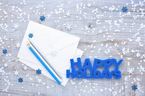 Groet Happy Holidays Potloden Enveloppen Sneeuwvlokken Een Lichte Houten Achtergrond — Stockfoto