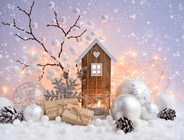 Composição de Natal com bolas decorativas, casa de brinquedo e vela na neve — Fotografia de Stock