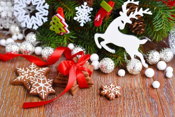 Biscuits de Noël avec décorations festives et branches d'épinette sur une table en bois — Photo