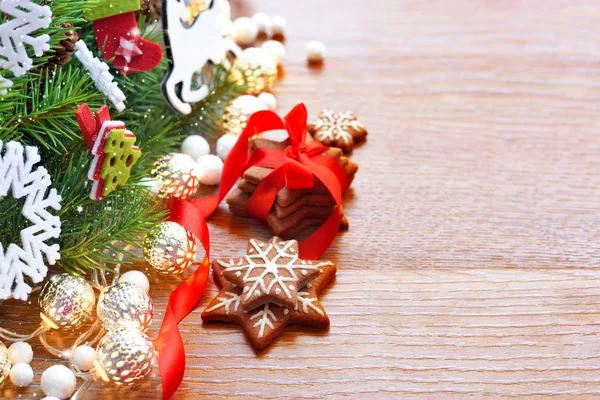 Galletas de Navidad con decoraciones festivas y ramas de abeto en una mesa de madera —  Fotos de Stock
