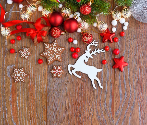 Biscoitos de Natal com decorações festivas e ramos de abeto em uma mesa de madeira — Fotografia de Stock