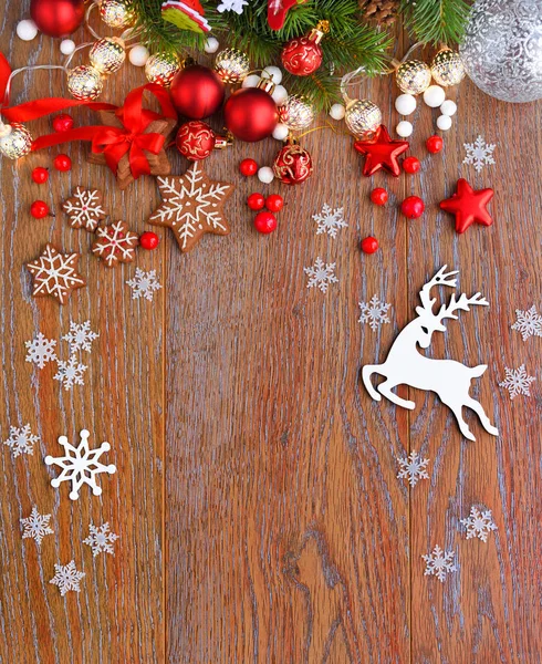 Kerstkoekjes met feestelijke decoraties en vuren takken op een houten tafel — Stockfoto