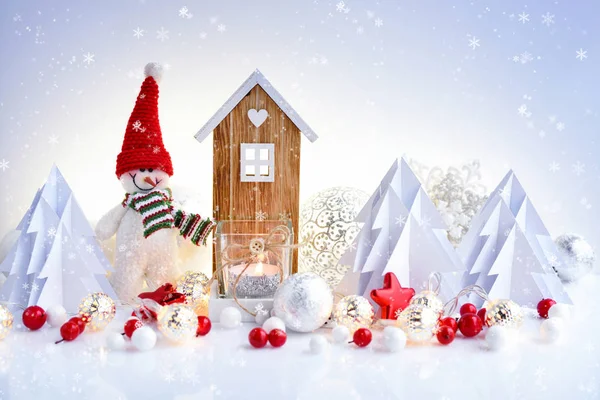 Muñeco de nieve con adornos de Navidad y casa de juguete y luces de Navidad . — Foto de Stock