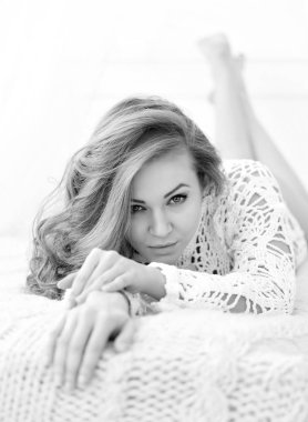 Güzel kadın evde yatağında yatarken. Baştan çıkarıcı beyaz kameraya görünüyor.