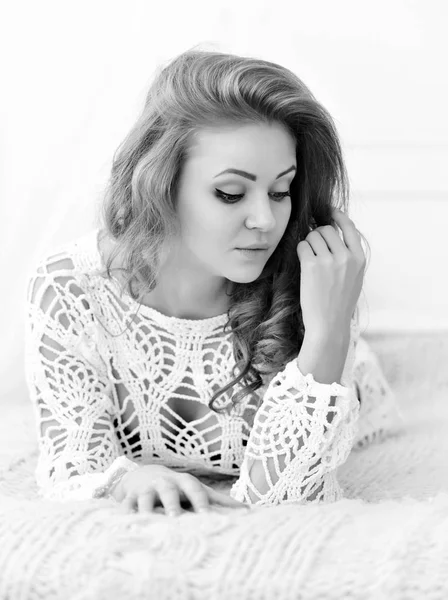 Pretty woman lying down on her bed at home. Seductive girl in white — Stock Photo, Image