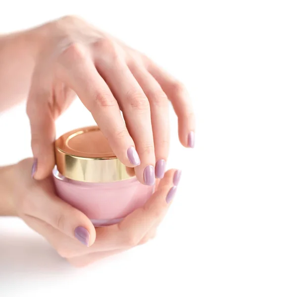 一个女人的手, 粉红色的指甲, 在白色背景的奶油罐子 — 图库照片