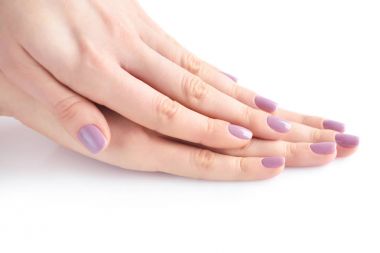 Elinde çivi beyaz arka plan üzerinde pembe manikür genç bir kadınla closeup