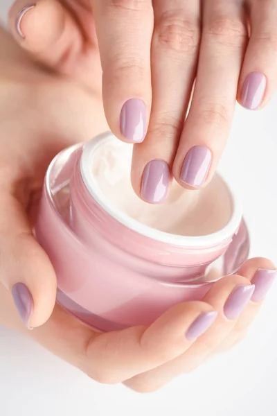 一个女人与奶油的粉红色指甲的手 — 图库照片