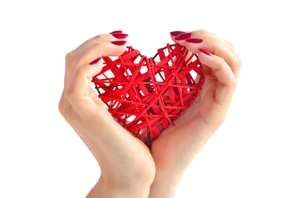 Wicker röda hjärtat i kvinnans händer på vit bakgrund. — Stockfoto