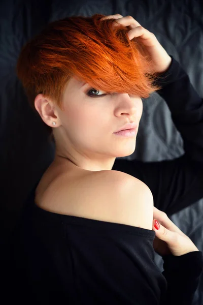 Retrato de uma bela jovem ruiva com cabelo curto em um fundo escuro — Fotografia de Stock