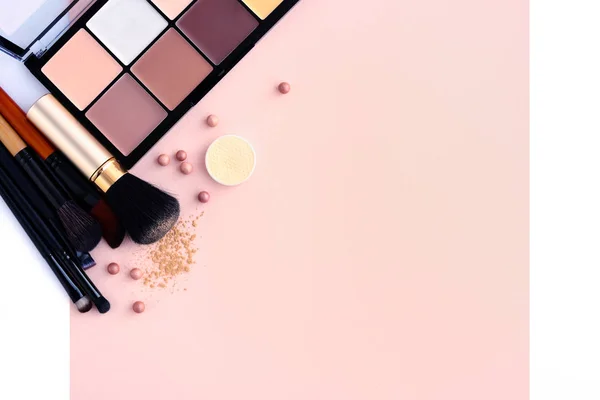 Cepillo de maquillaje y cosméticos decorativos sobre un fondo rosa pastel con espacio vacío — Foto de Stock