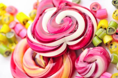 Renkli şekerler ve beyaz bir arka plan üzerinde lolipop