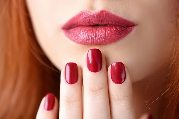 Piękna Rudowłosa młoda kobieta z czerwonym manicure, szminka samego koloru — Zdjęcie stockowe