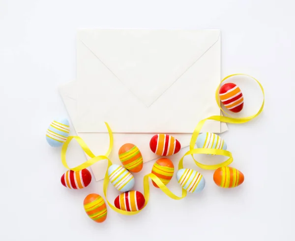 Праздничный фон с пасхальными яйцами с лентами и конвертами . — стоковое фото