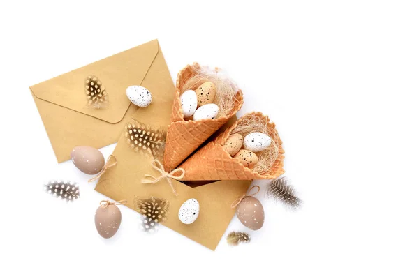 Κώνους βαφλών με Πασχαλινά αυγά με φακέλους σε λευκό φόντο — Φωτογραφία Αρχείου