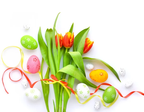 Ostereier mit Tulpen auf weißem Hintergrund. Ansicht von oben. — Stockfoto