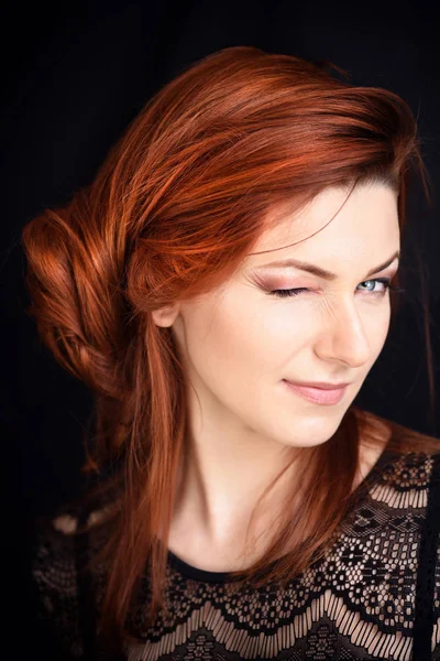 Portrait of a beautiful young woman with long red hair on a dark background — Stock Photo, Image