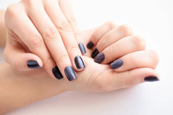 Primer plano de las manos de una joven con manicura oscura en las uñas —  Fotos de Stock