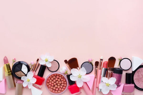 Cepillo de maquillaje y cosméticos decorativos con flor de manzana sobre un fondo rosa pastel —  Fotos de Stock