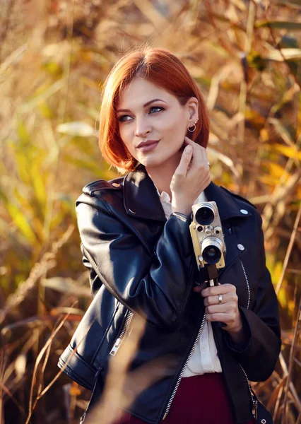 Güzel kızıl saçlı kadın elinde bir video kamera tutuyor. — Stok fotoğraf