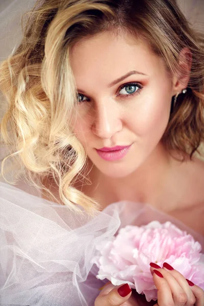 Egy fiatal szőke nő portréja rózsaszín virággal — Stock Fotó