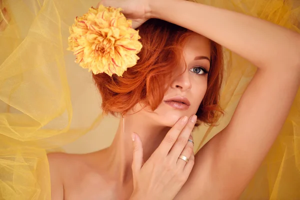 Portrait de jeune belle femme rousse à fleur jaune — Photo