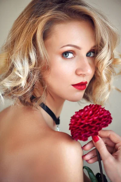 Portret młodej blondynki z czerwonym kwiatem — Zdjęcie stockowe
