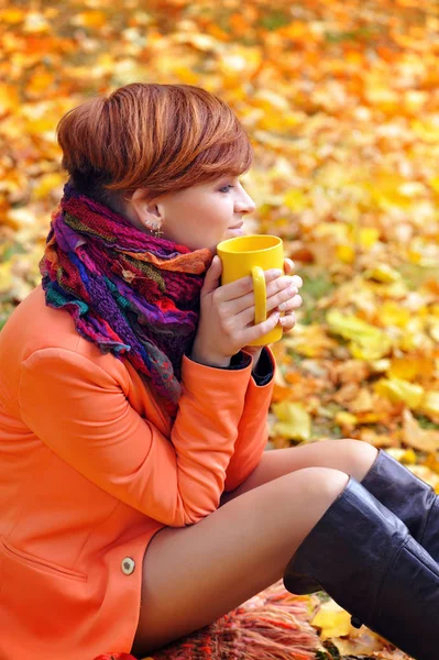 Jonge mooie vrouw die de kop thee in handen houdt — Stockfoto