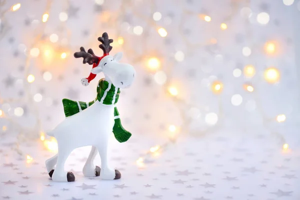 Kerst achtergrond met decoratieve eland op feestelijke verlichting achtergrond — Stockfoto